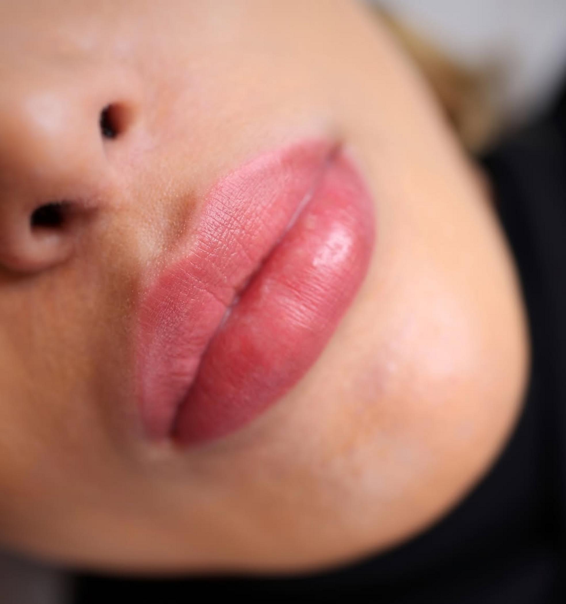 technician applying lip tattoo pigment
